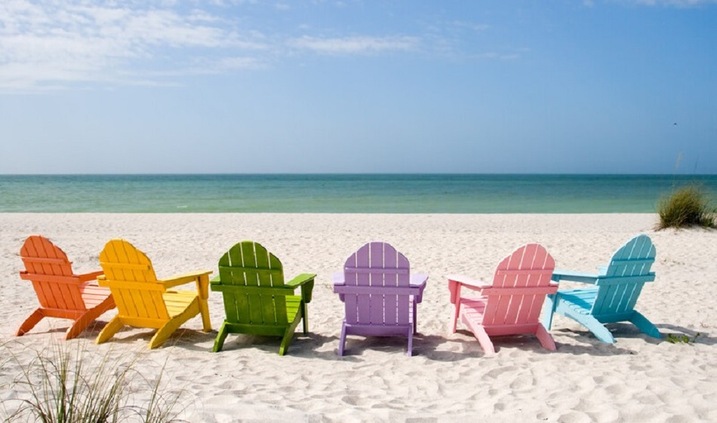 A picture of Clearwater Beach with beach amenities such as umbrellas, chairs, and towels visible in the foreground.